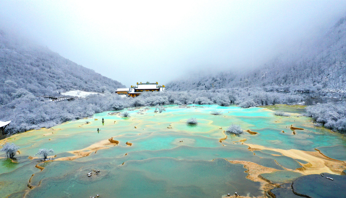 雪中黄龙景区如仙境看钙华池与白雪融合之美