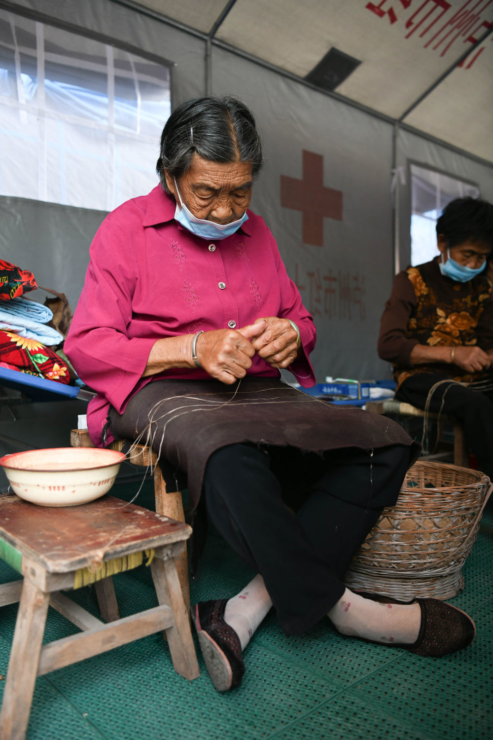 9月21日,泸县福集镇人文菊芳在安置点内搓麻线.新华社记者胥冰洁摄