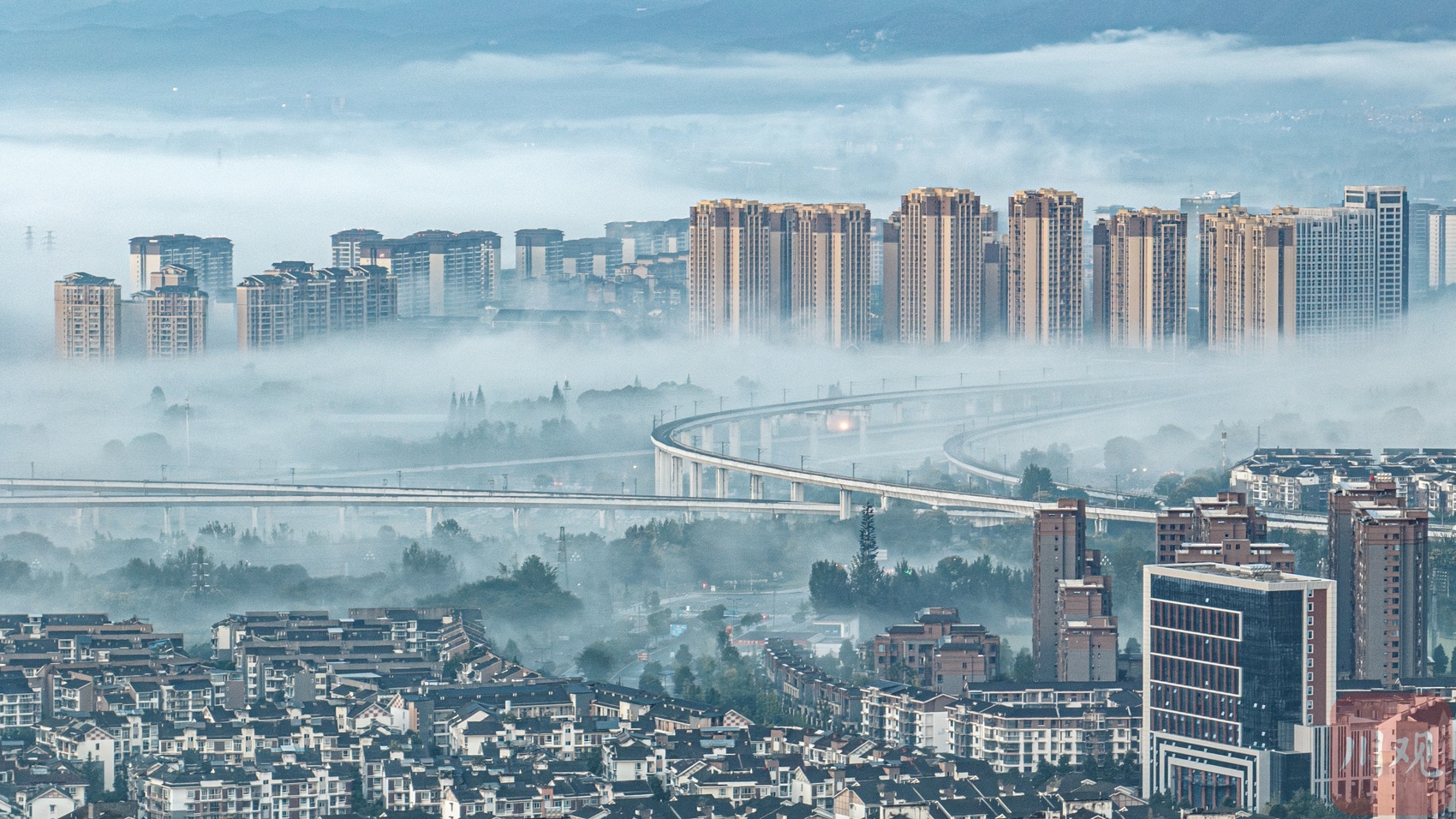 都江堰高鐵站周邊,瀰漫著晨霧.大雨之後的都江堰,迎來了日出和雲海.